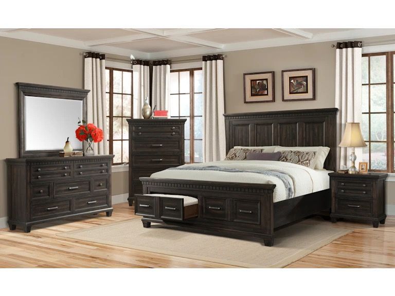A bedroom with a bed , dresser , nightstand and mirror.