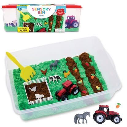 Sensory bin farm playset with green and brown sand, tractor, animals, and tools.