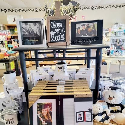 Graduation gifts on display: frames, mugs, teddy bears, and signs that read 