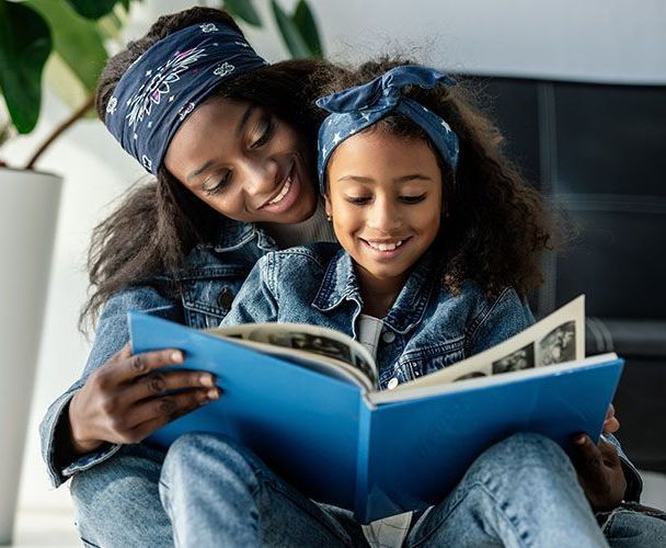 A mother and daughter are reading a book together.