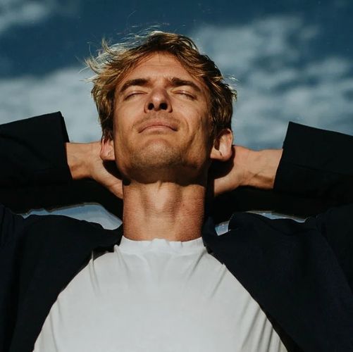 Man outdoors with his face to the sky, energy and focus restored