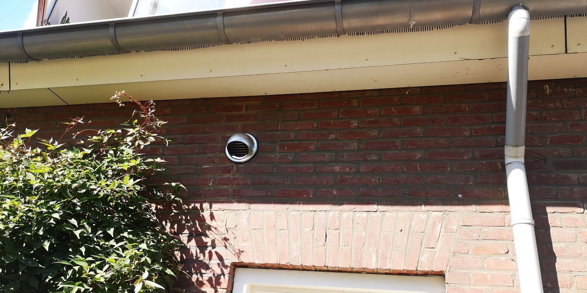 Bolrooster op muur geplaatst in gat voor mobiele airco