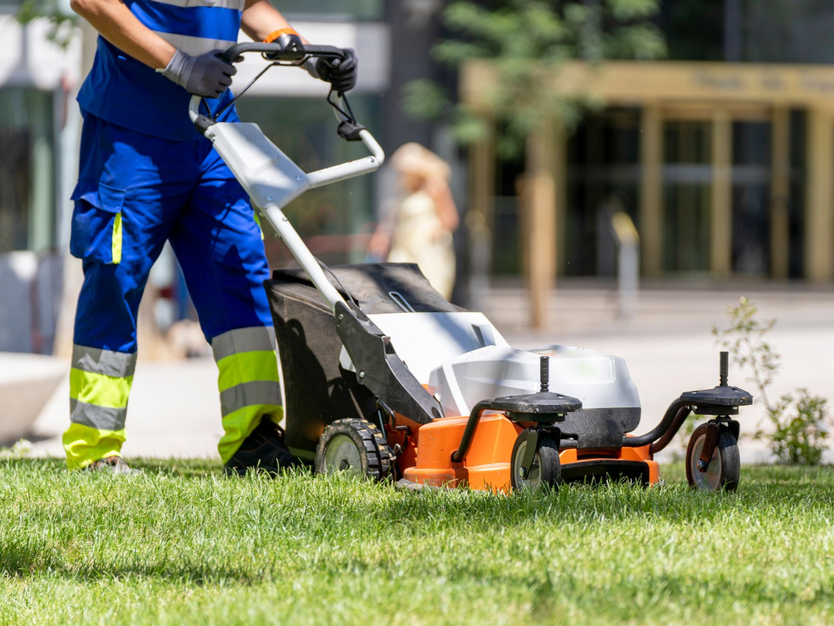 Lawn care professional mowing a grassed area