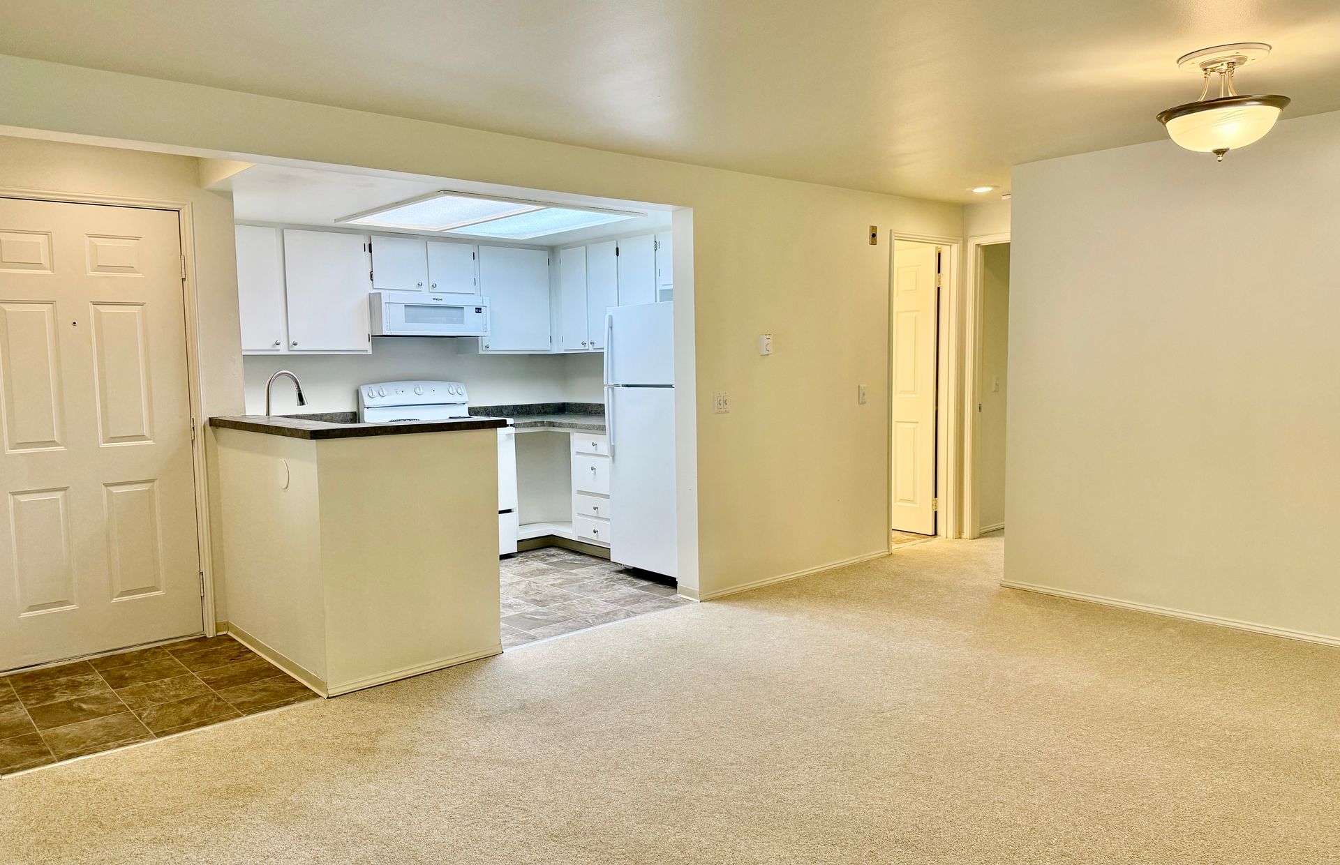 A kitchen with white cabinets and a stainless steel refrigerator