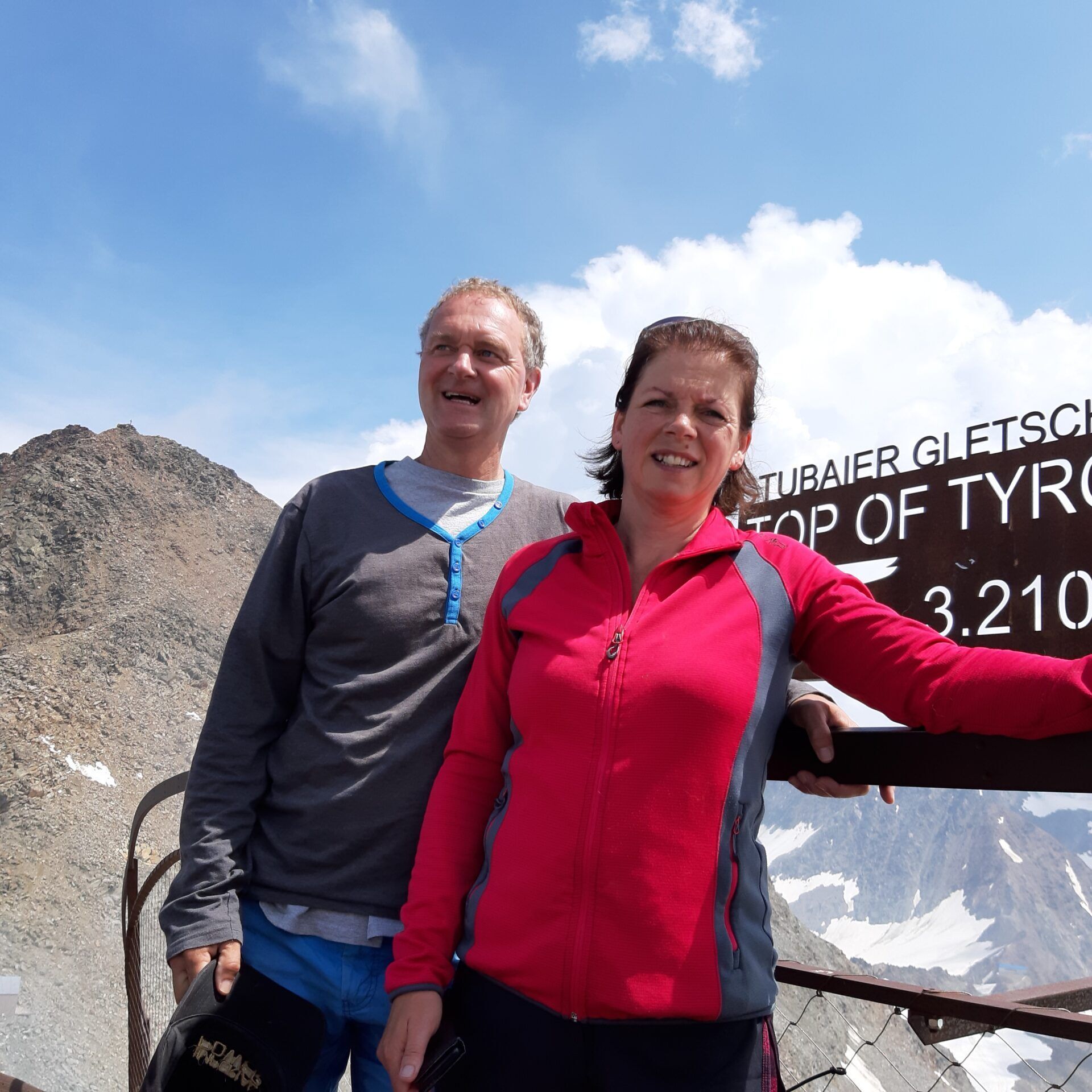 Een man en een vrouw staan voor een bord met de tekst top of tyr