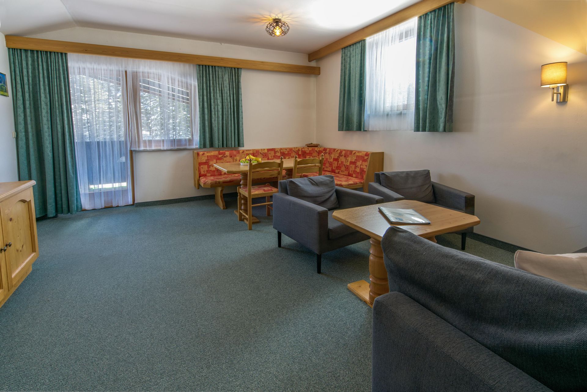 A living room with a couch , chairs , a table and a balcony.