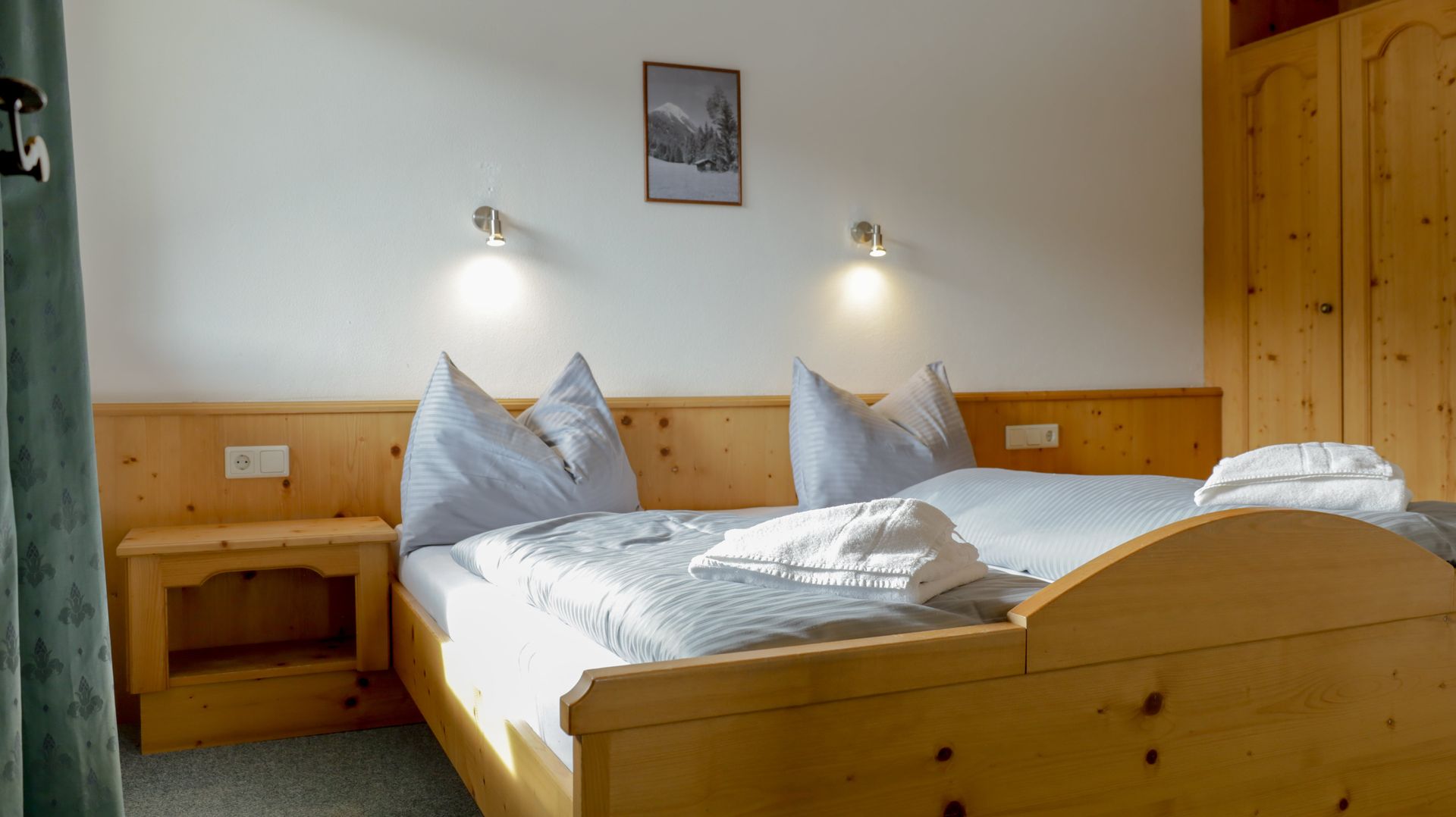 Ein Schlafzimmer mit zwei Betten, einem Nachttisch und einem Bild an der Wand.