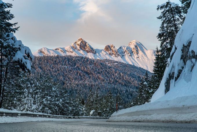 Eine verschneite Straße mit Bergen im Hintergrund