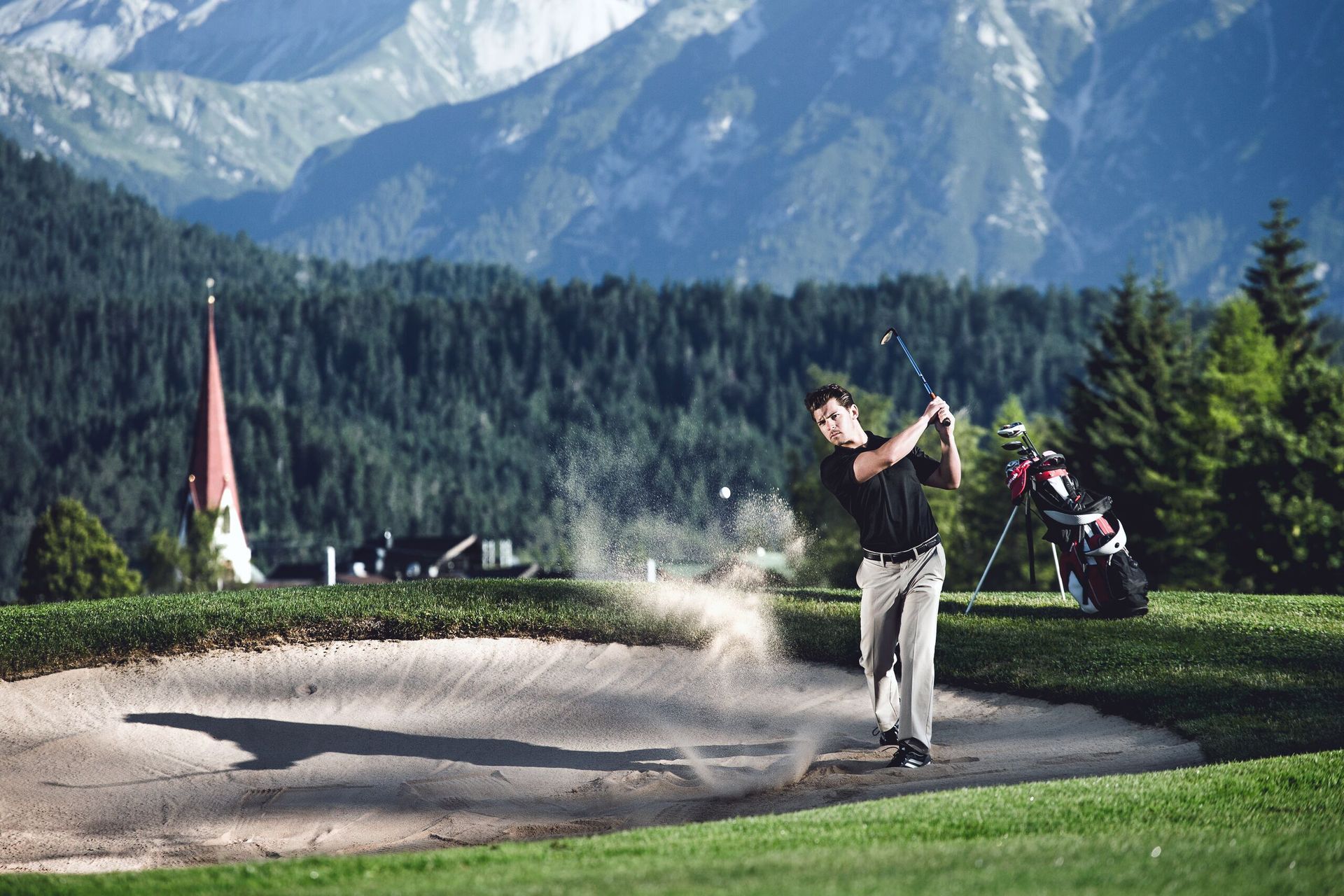 Ein Mann schlägt einen Golfball aus einem Bunker auf einem Golfplatz.
