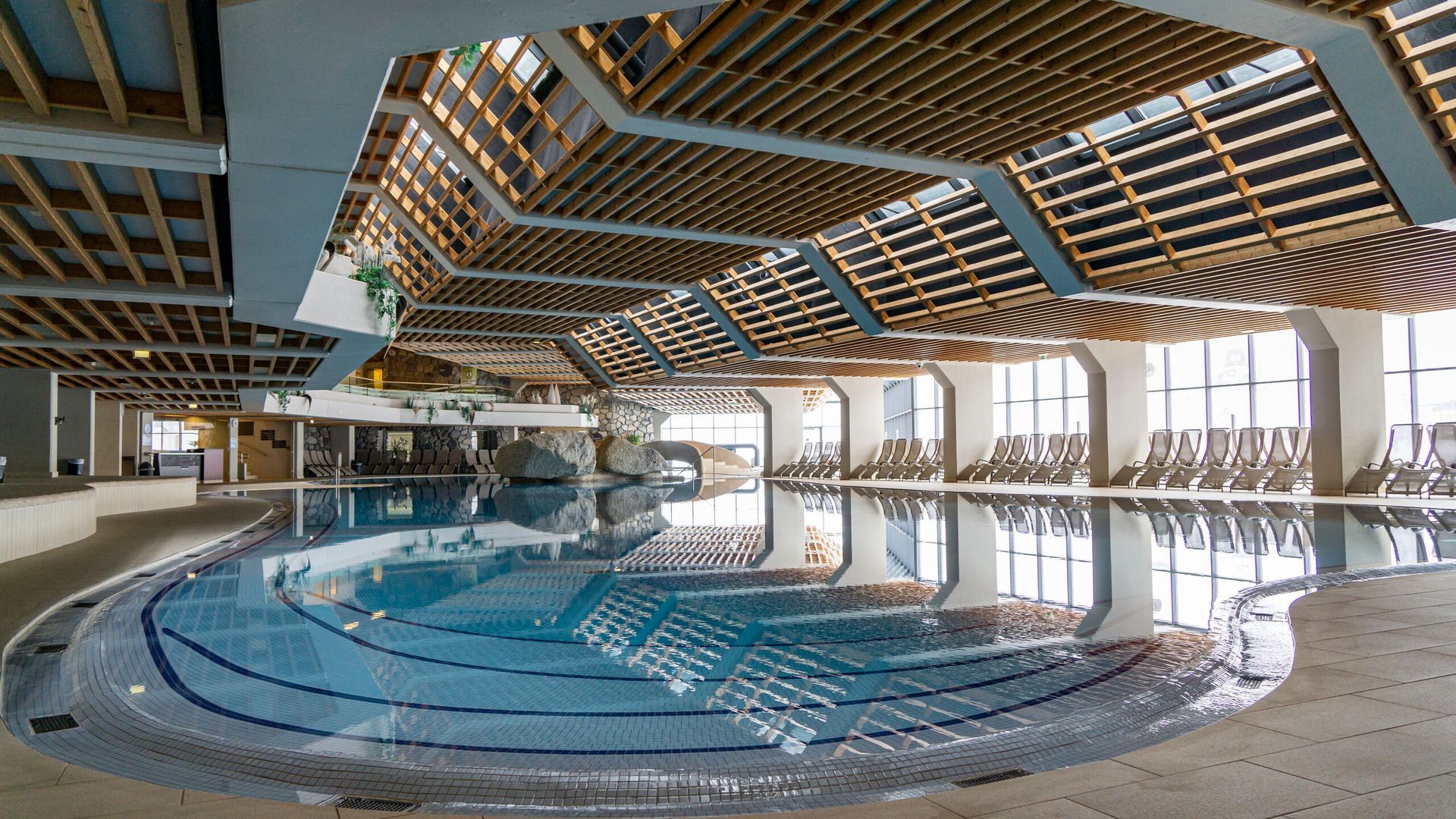 Ein großes Hallenbad mit Holzdecke