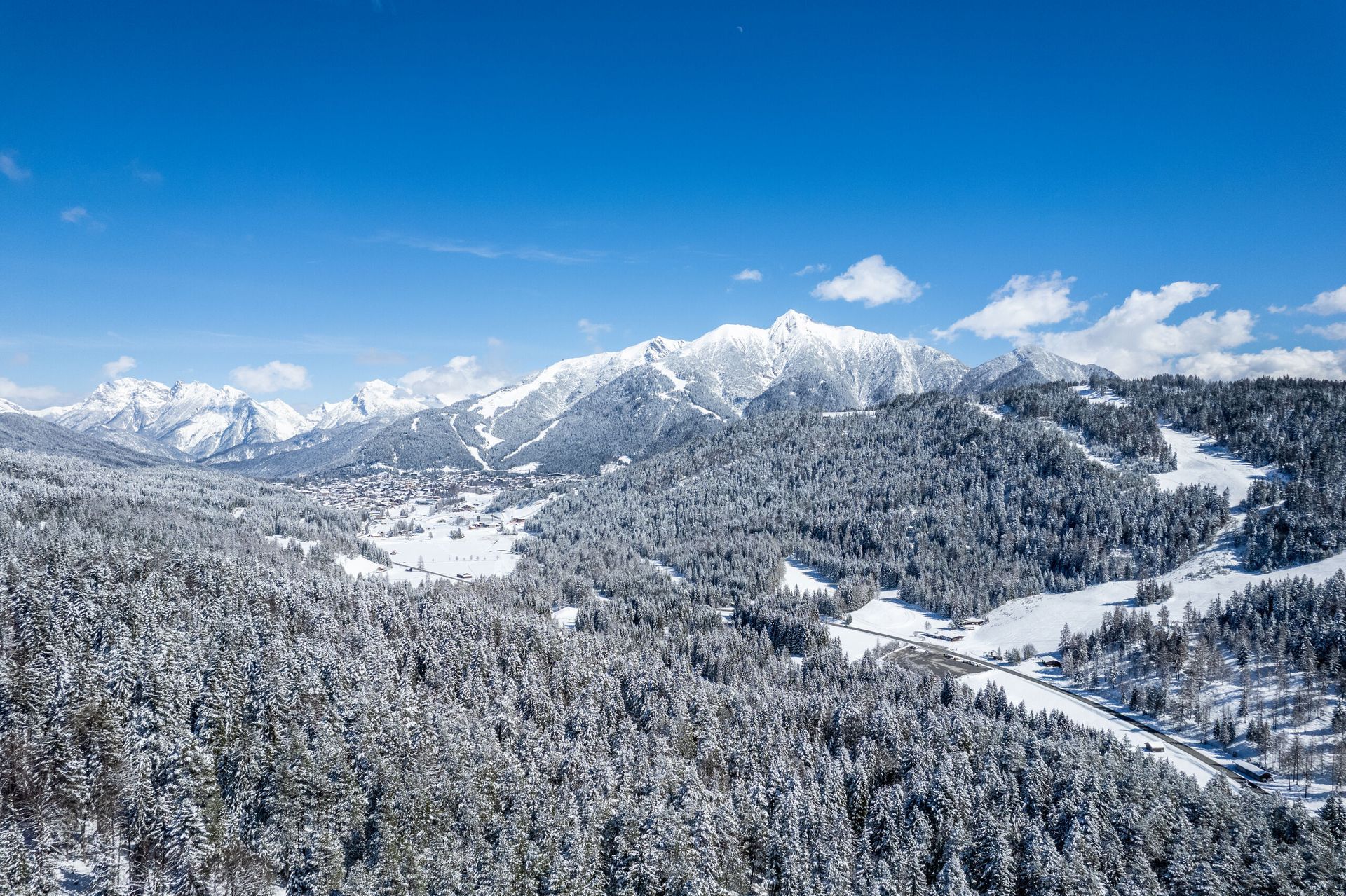 Eine Luftaufnahme einer schneebedeckten Bergkette mit schneebedeckten Bäumen.