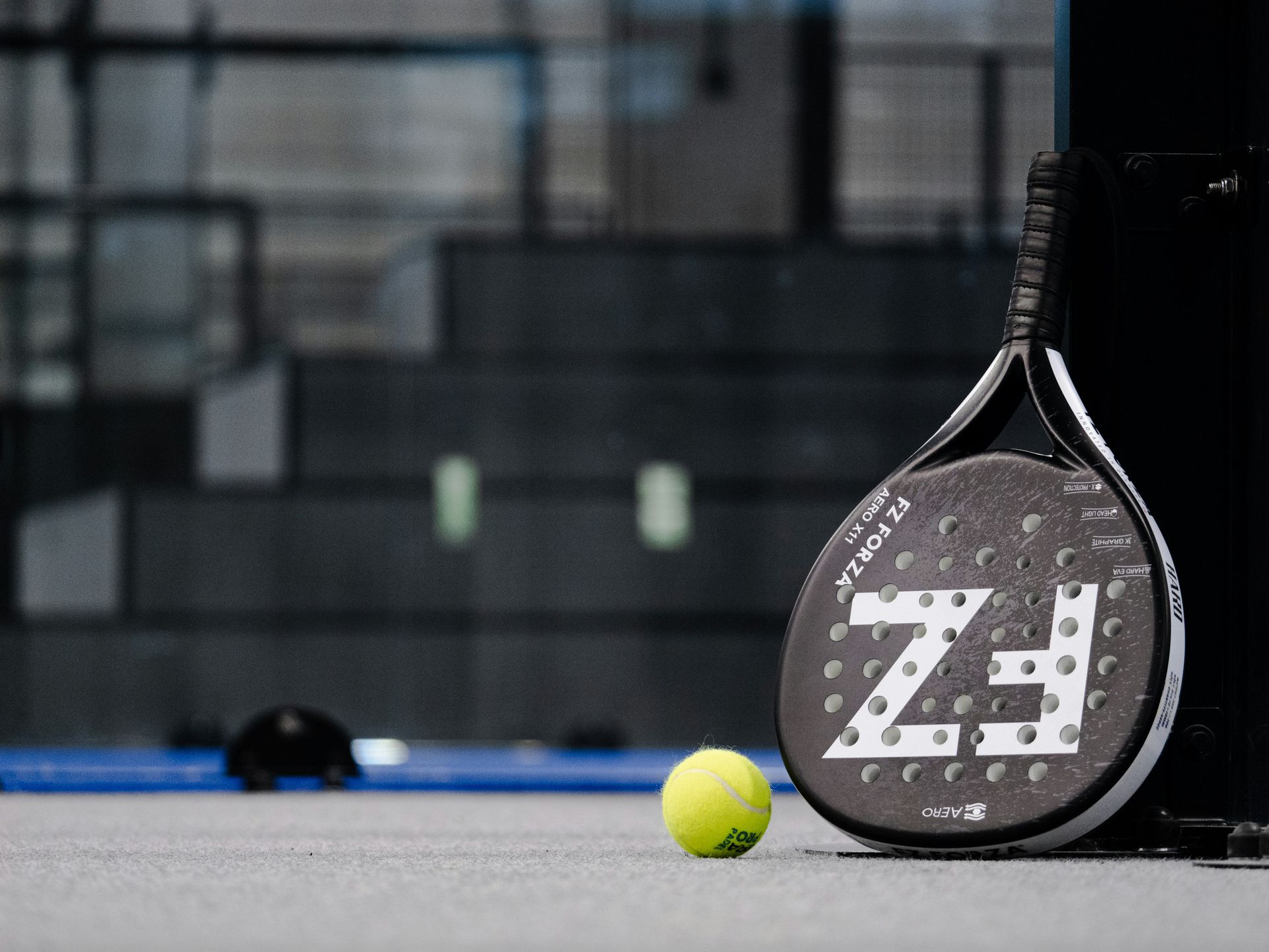 Ein Tennisball und ein Schläger auf einem Tennisplatz.