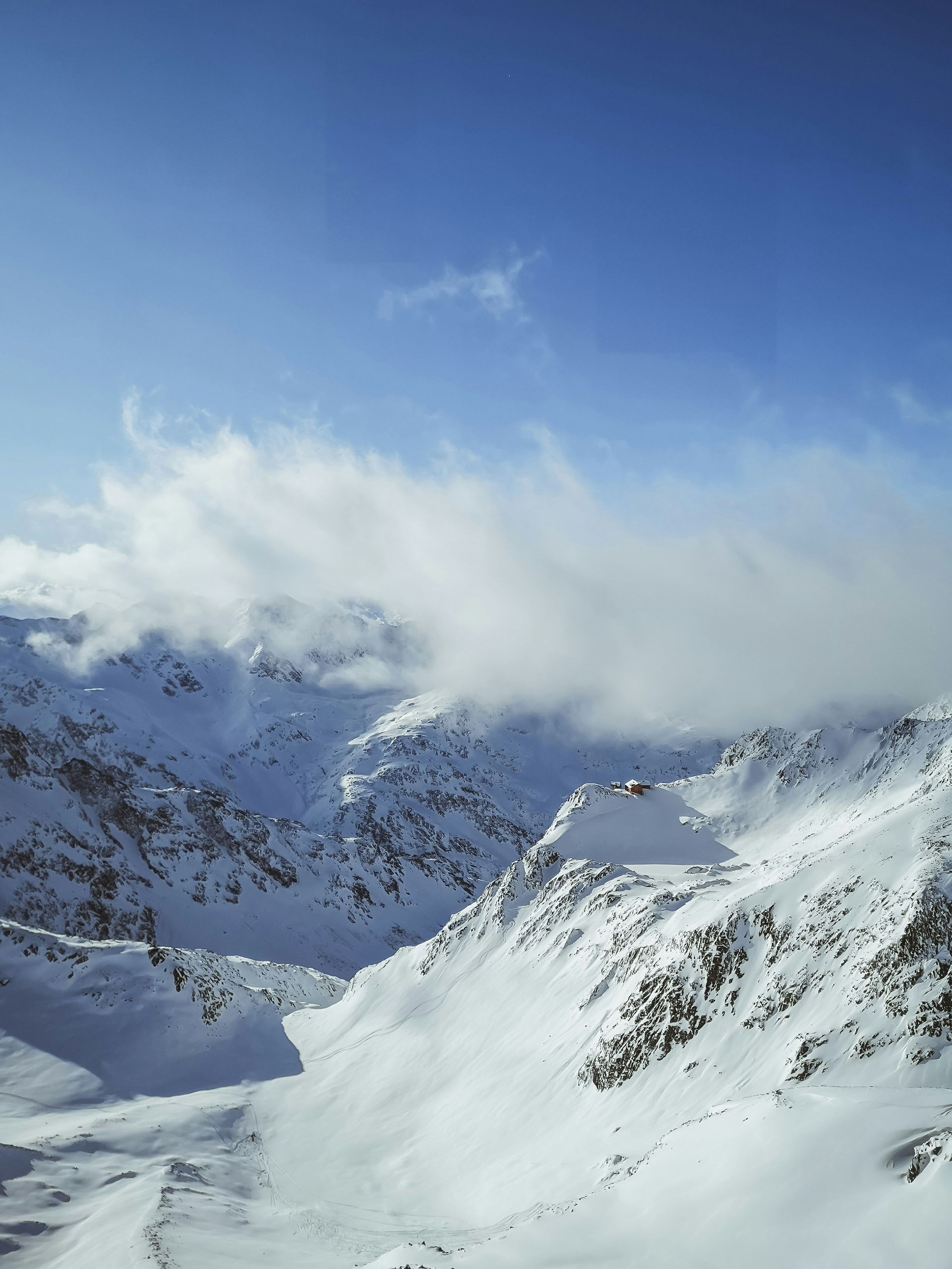 Skifahrerin auf einer verschneiten Piste mit Blick auf die Tiroler Berge