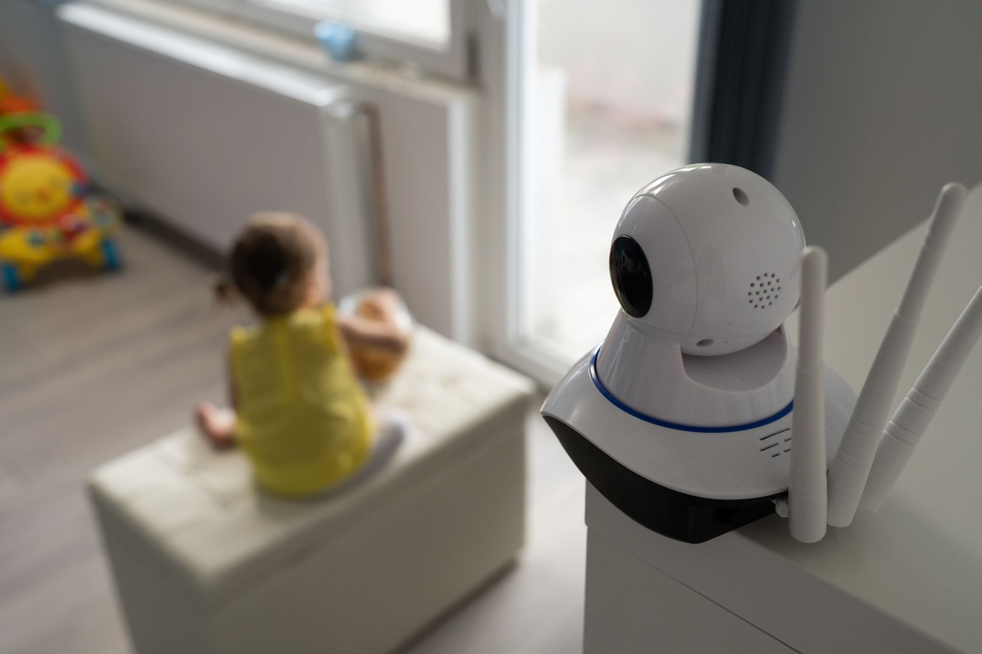 a small child sits on a stool in front of a security camera