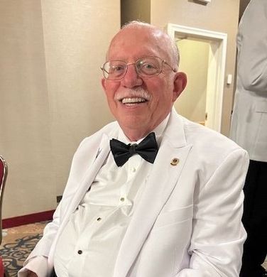 A man with a beard is wearing a suit and tie