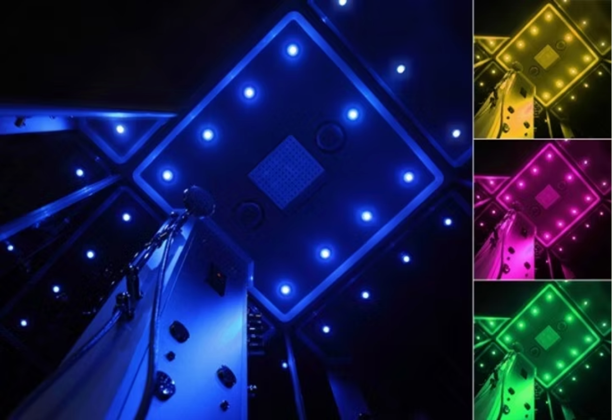 Installation lumineuse abstraite au néon avec des formes de losanges bleues, jaunes, magenta et vertes lumineuses sur fond sombre