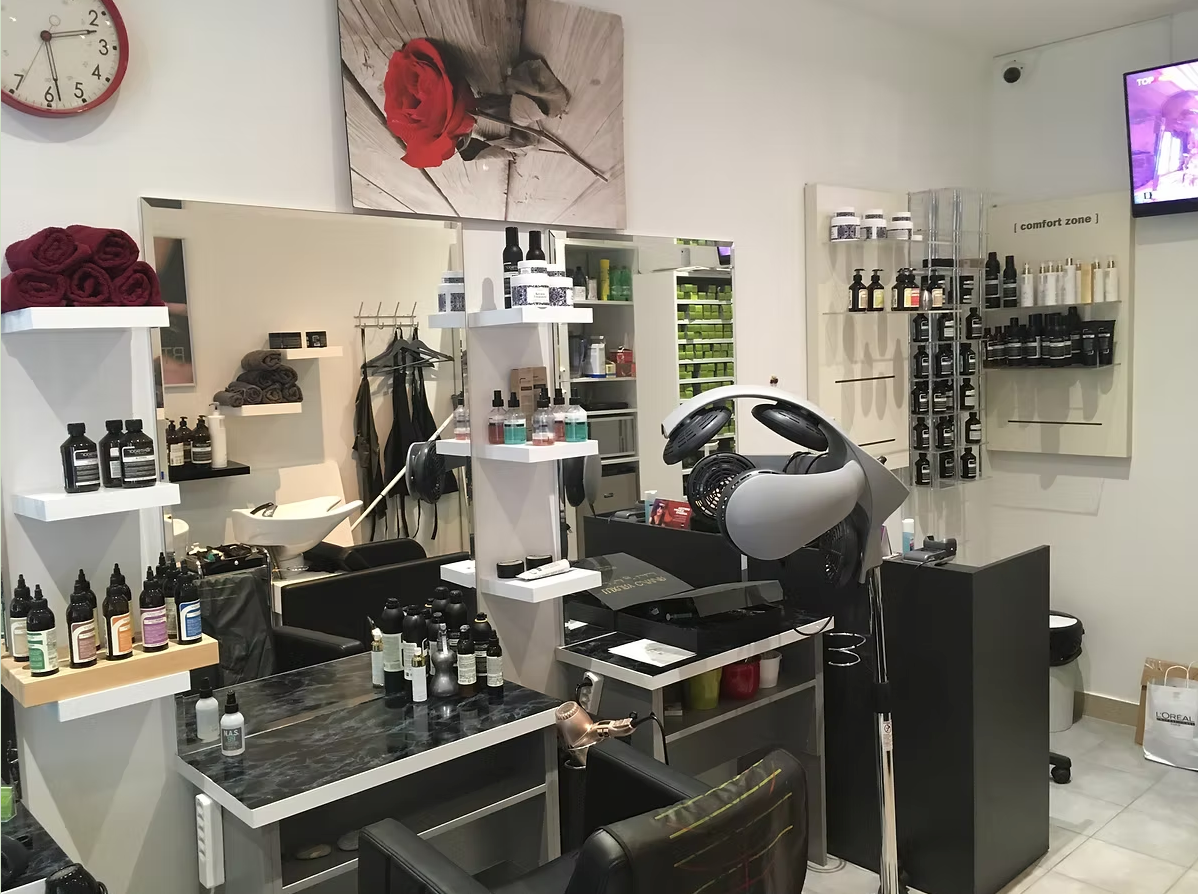 Intérieur d'un salon de coiffure avec fauteuils de coiffure, miroirs, étagères à produits et horloge murale