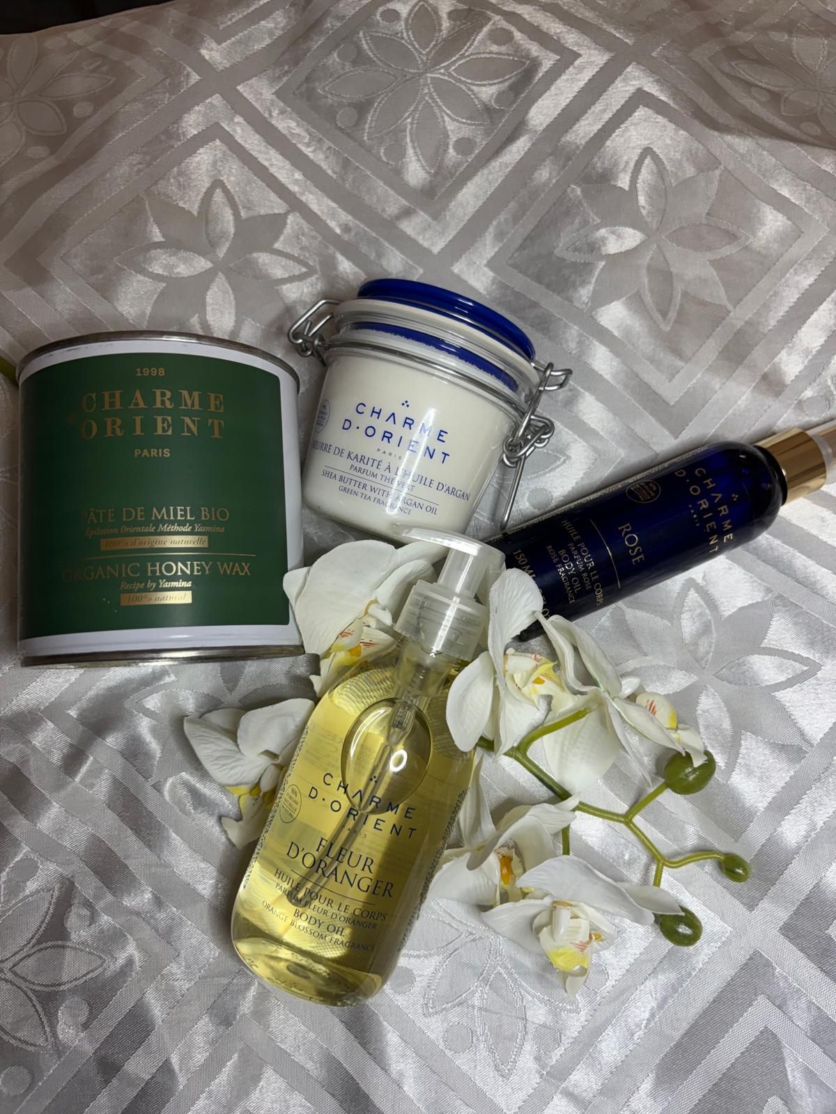 Produits de soin de la peau assortis et flacons d'échantillons disposés sur un tissu blanc à motifs