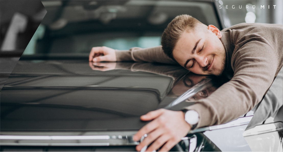 Um homem está abraçando o capô de um carro.