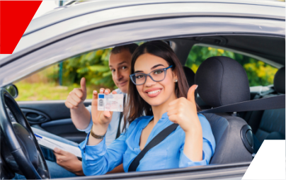 Um homem e uma mulher estão sentados em um carro fazendo sinal de positivo.