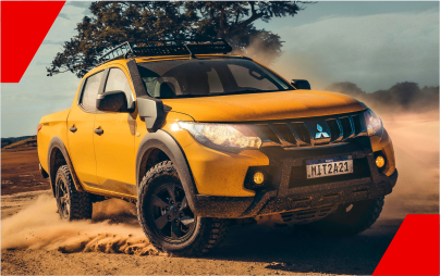 Um carro amarelo está dirigindo por uma estrada de terra.