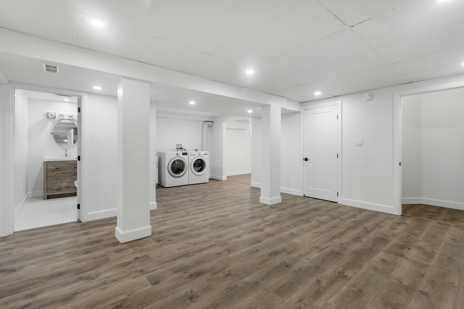 Cuisine moderne avec un grand îlot central, des appareils électroménagers en acier inoxydable et un parquet.