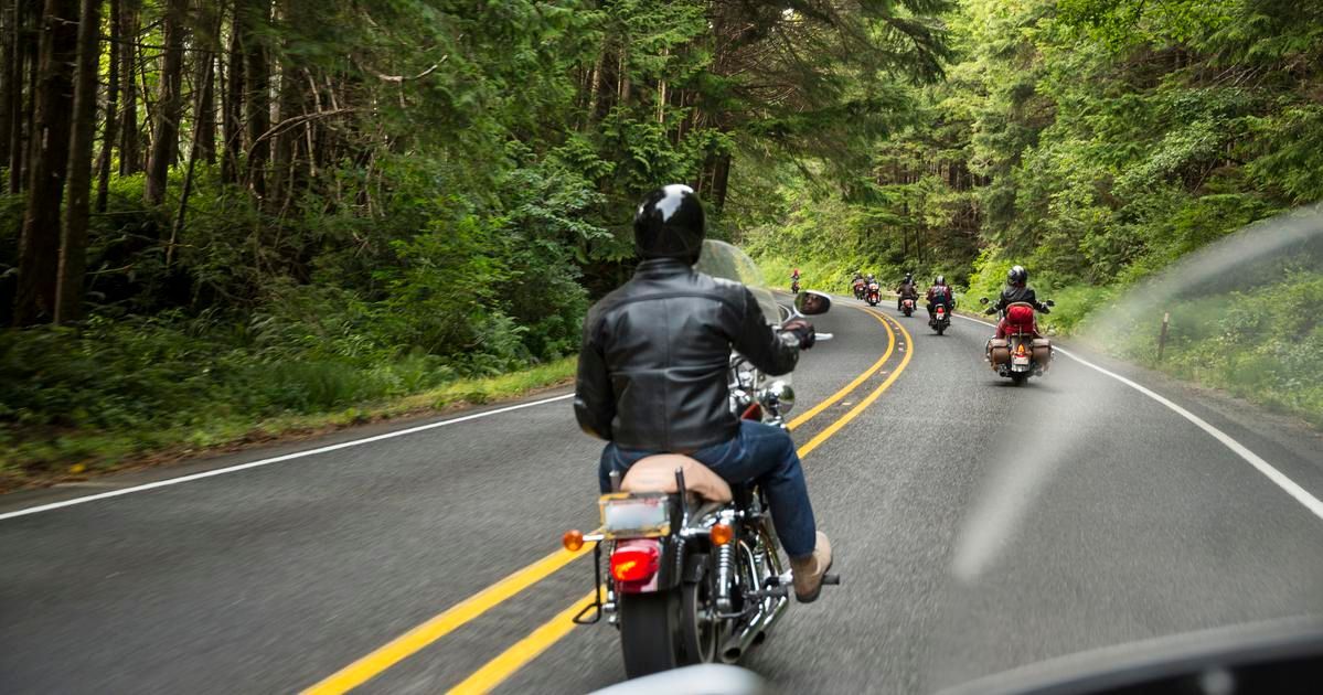 individual drives a motorcycle down a beautiful road knowing they have insurance