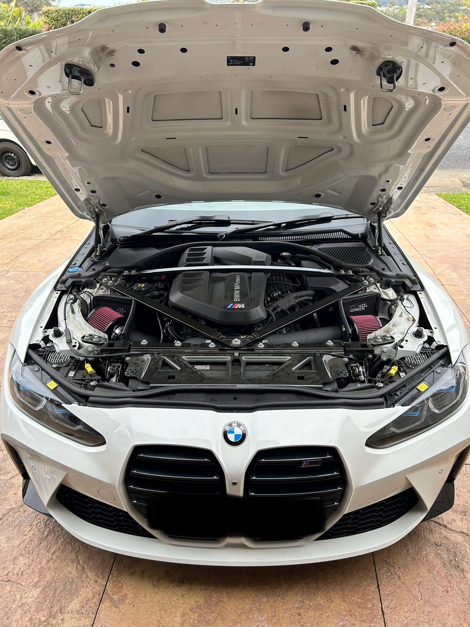 White BMW with hood open, showing the engine bay in a driveway — All Auto & Mechanical in The Entrance North, NSW
