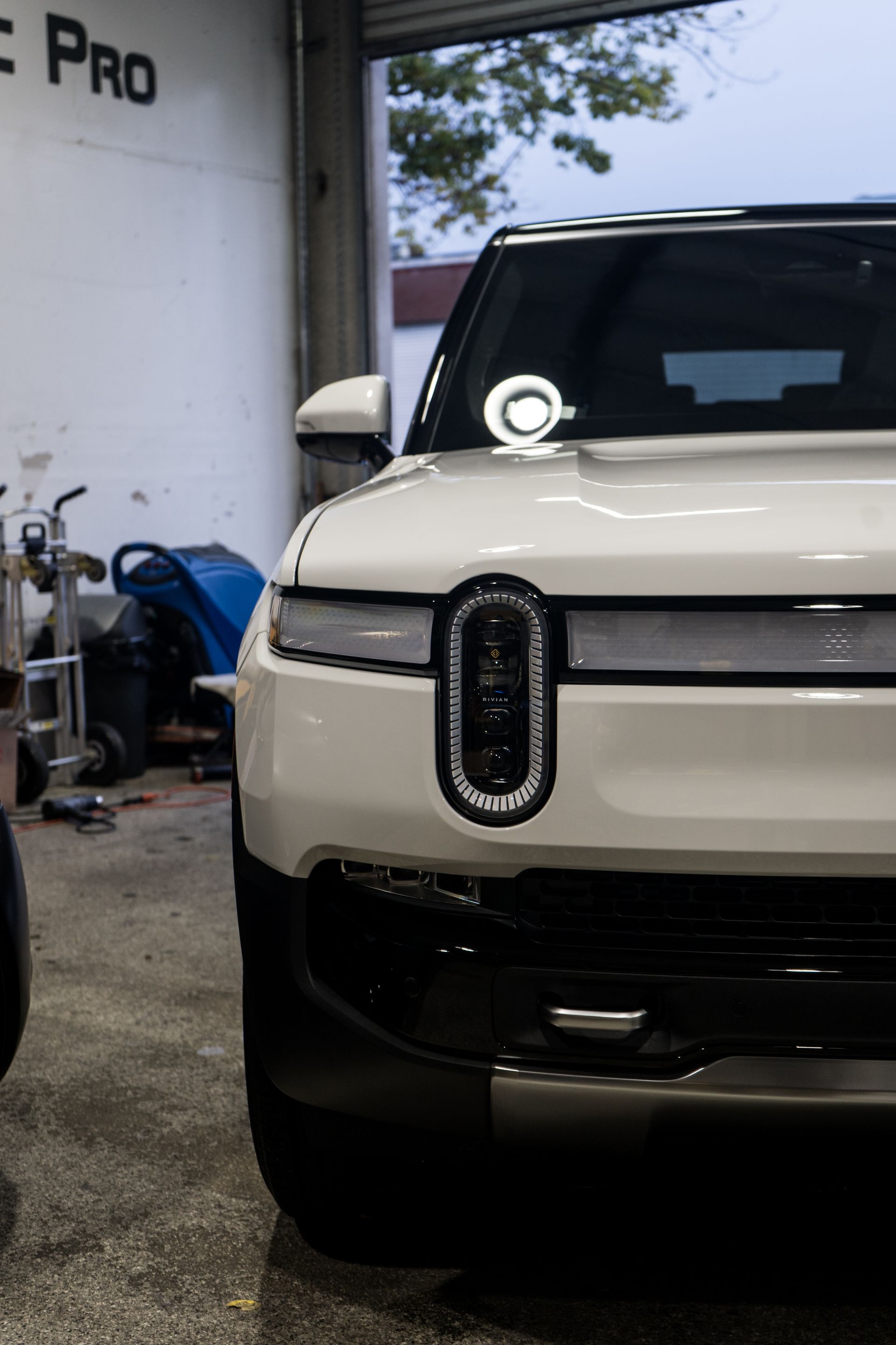 A white suv is parked in a garage with the door open.
