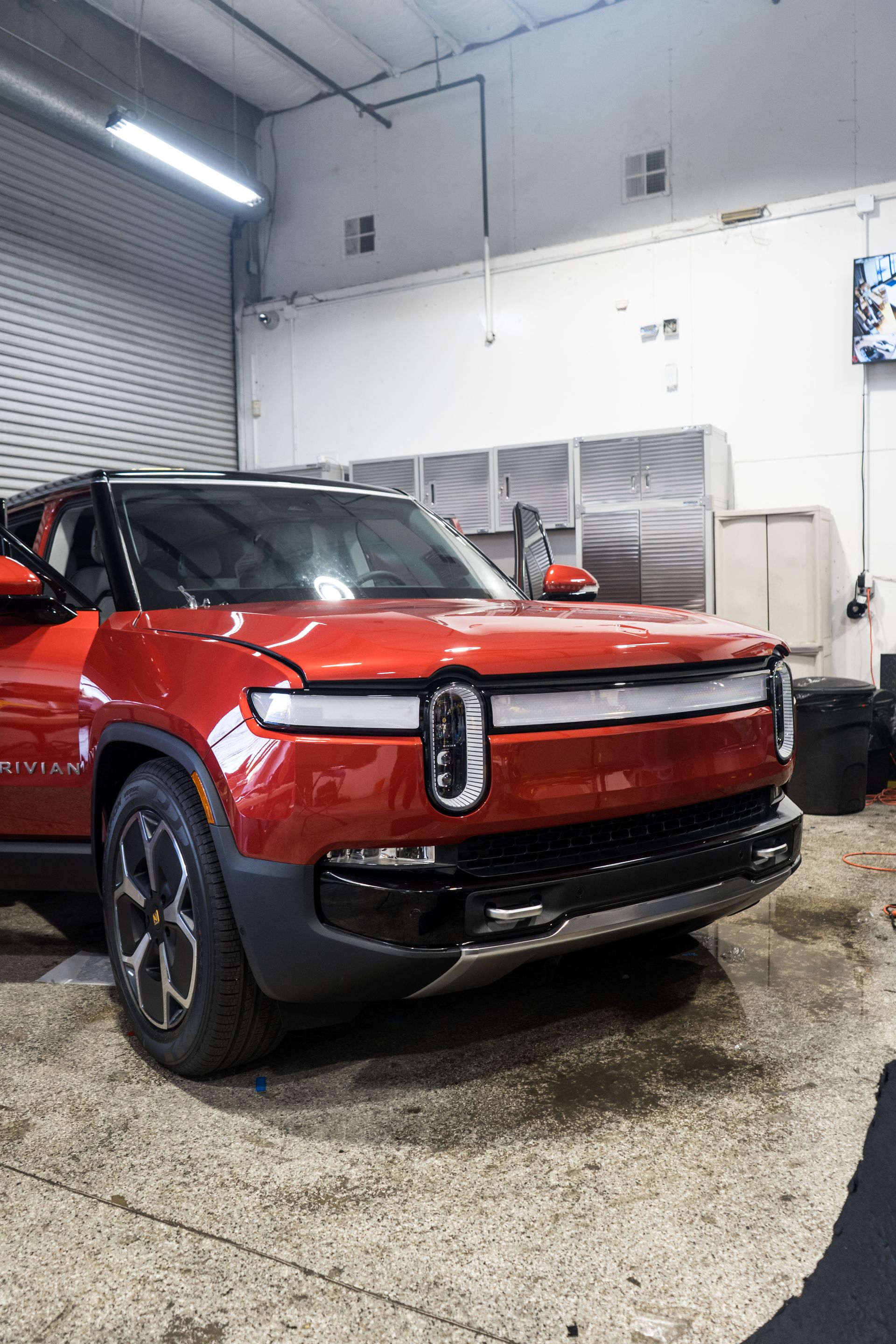 A red car is parked in a garage.