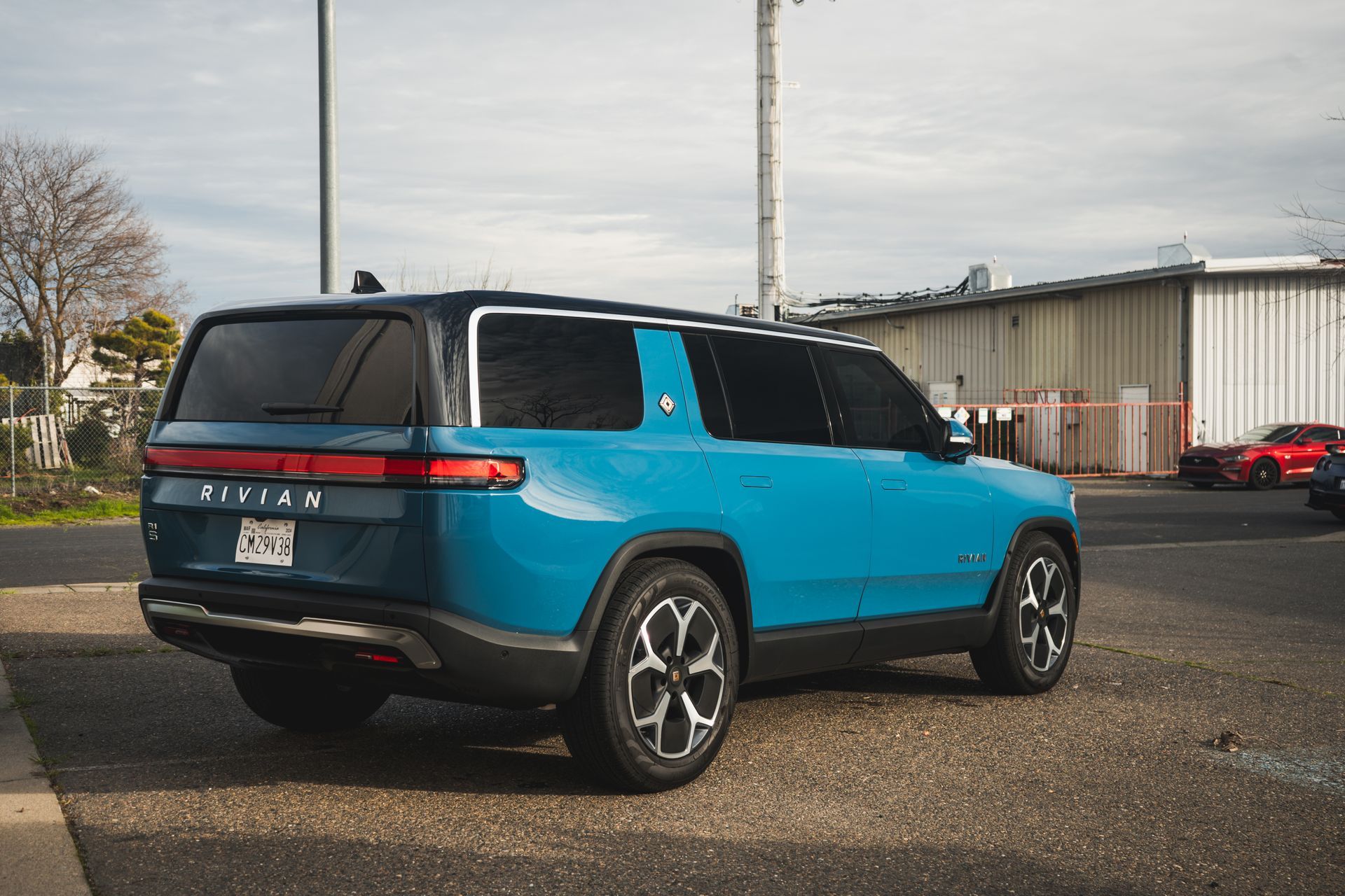 A blue suv is parked in a parking lot in front of a building.