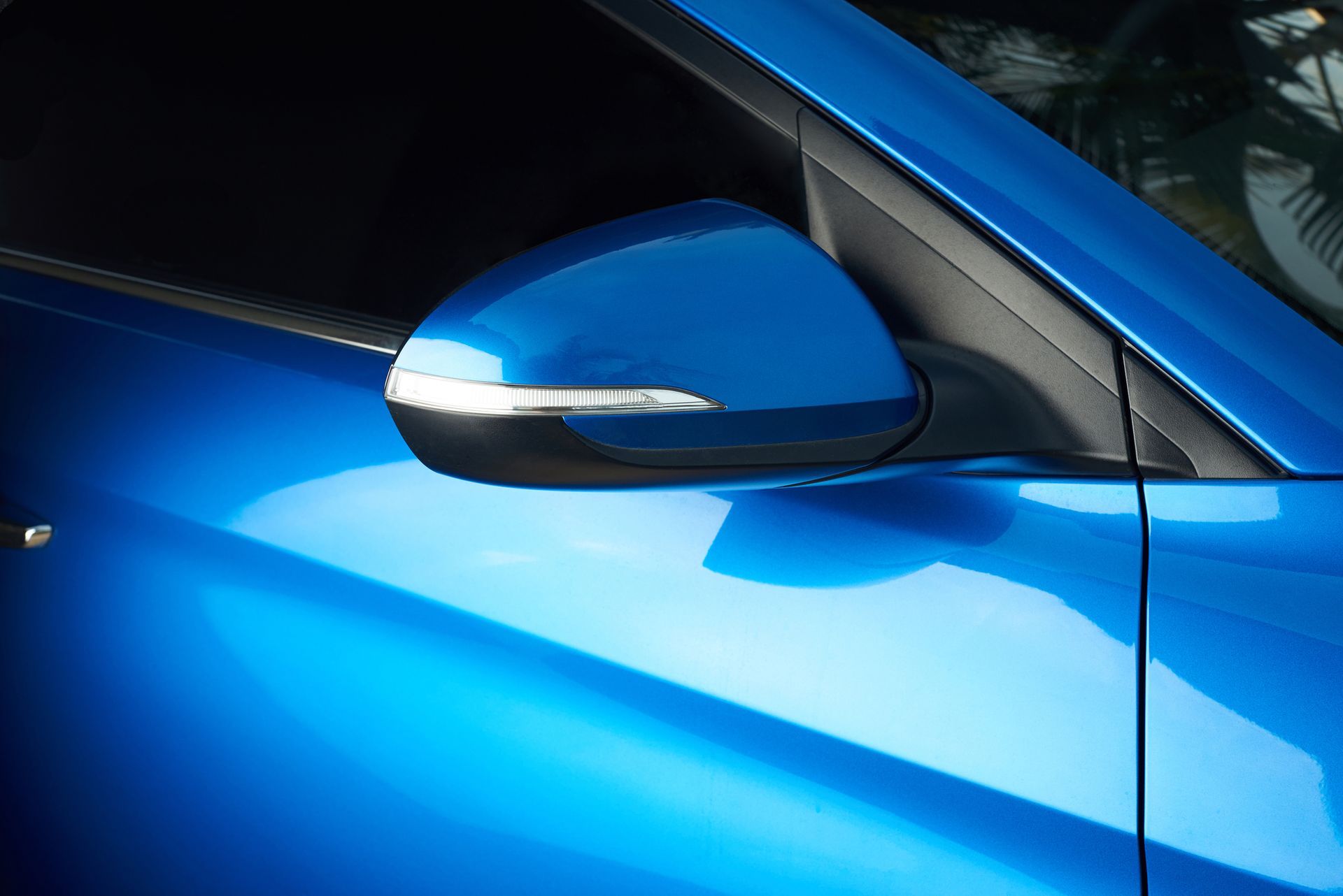 A close up of a blue car 's side mirror
