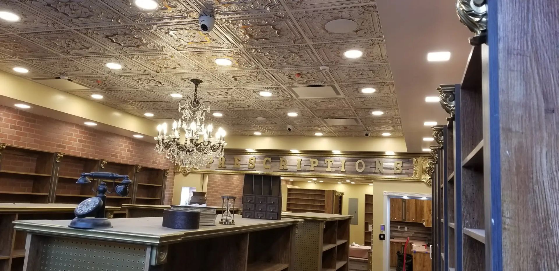 Empty, warmly lit bookstore interior with shelves, tables, and ornate ceiling decorations
