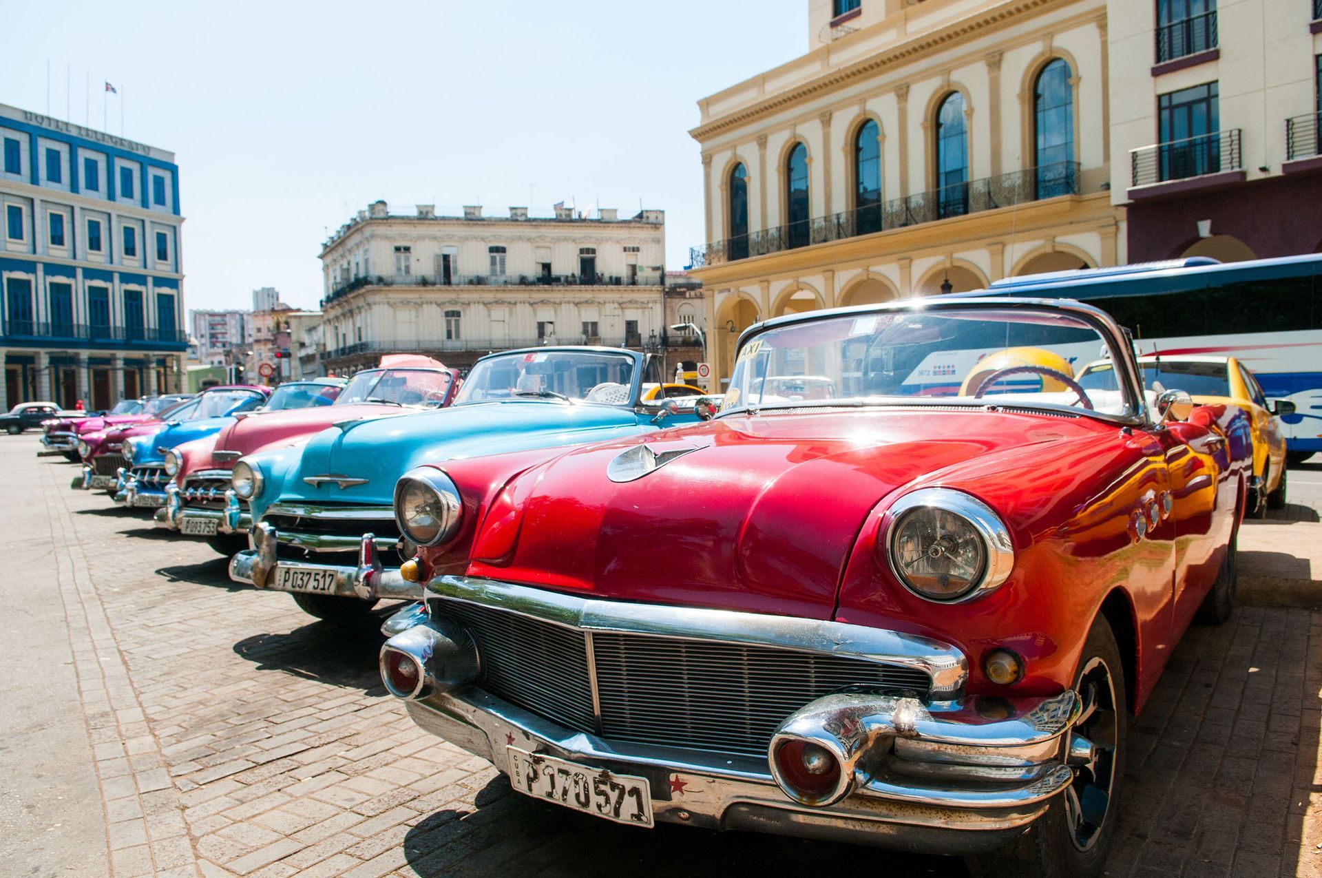 a row of classic cars are parked in front of a building