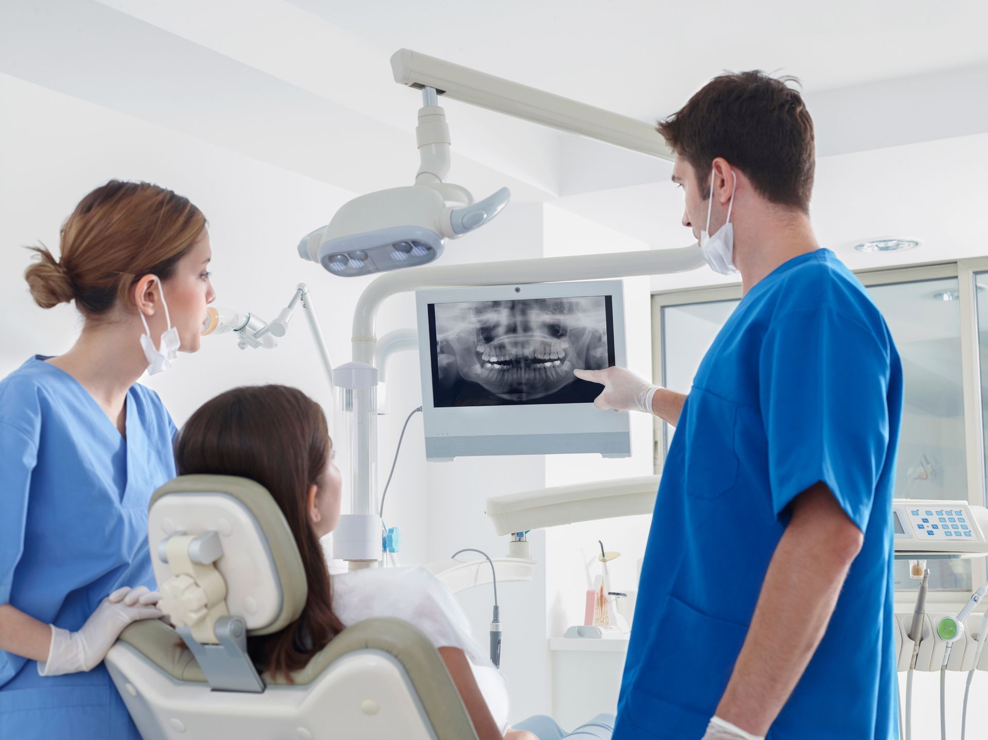 Dentists consulting with a patient over X-ray exams at a dentist office in Glendale Heights, IL.