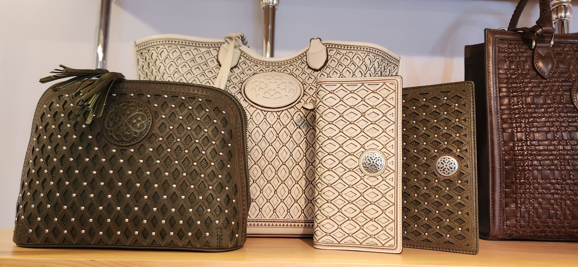 Assorted woven handbags in brown, beige, and cream displayed in a row