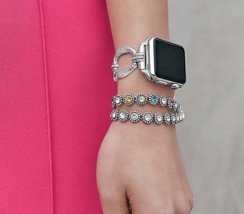 A woman wearing a watch and two bracelets on her wrist.