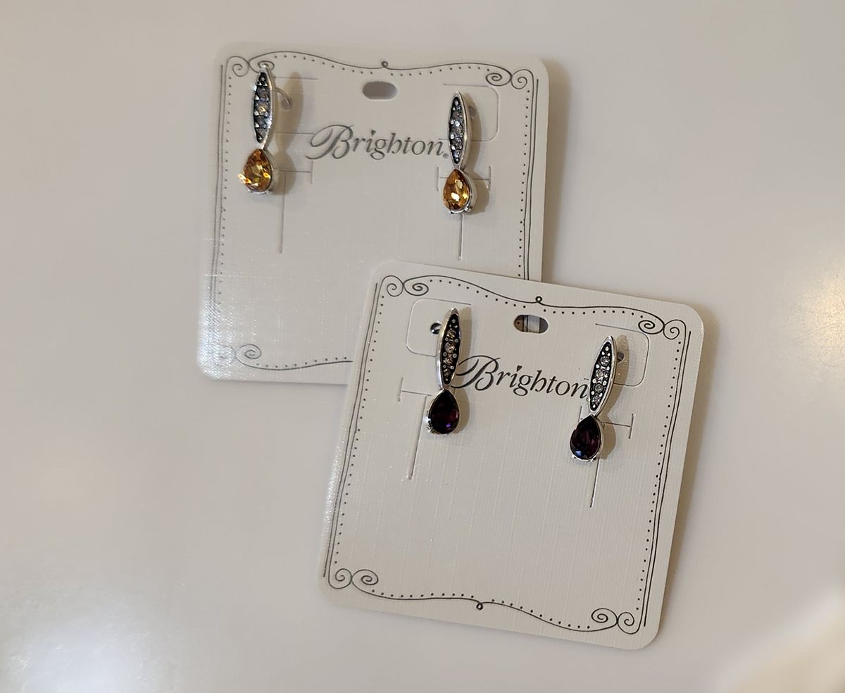 Two pairs of dangling earrings on decorative white jewelry cards