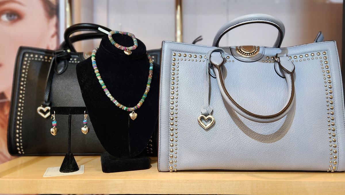 Black, black velvet, and silver handbags displayed on a shelf with jewelry accents