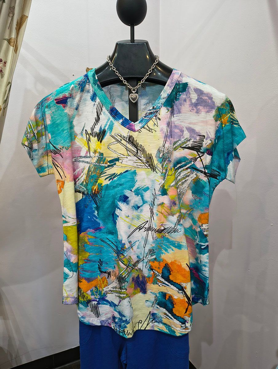 Colorful abstract print V-neck T-shirt on a mannequin, with teal, yellow, pink, and white accents.