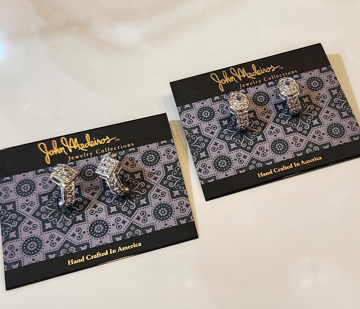 Two black lace-and-gold jewelry cards with matching earrings on a white background