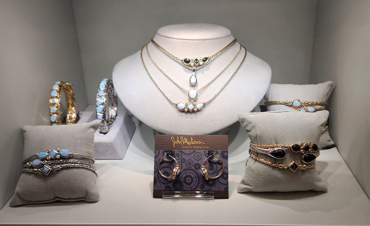 Jewelry display with diamond necklaces, bracelets, rings, and earrings on gray stands