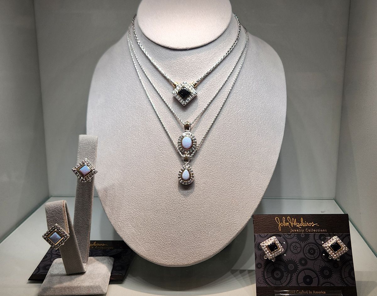 Jewelry display with diamond necklaces, rings, and earrings on gray velvet stands
