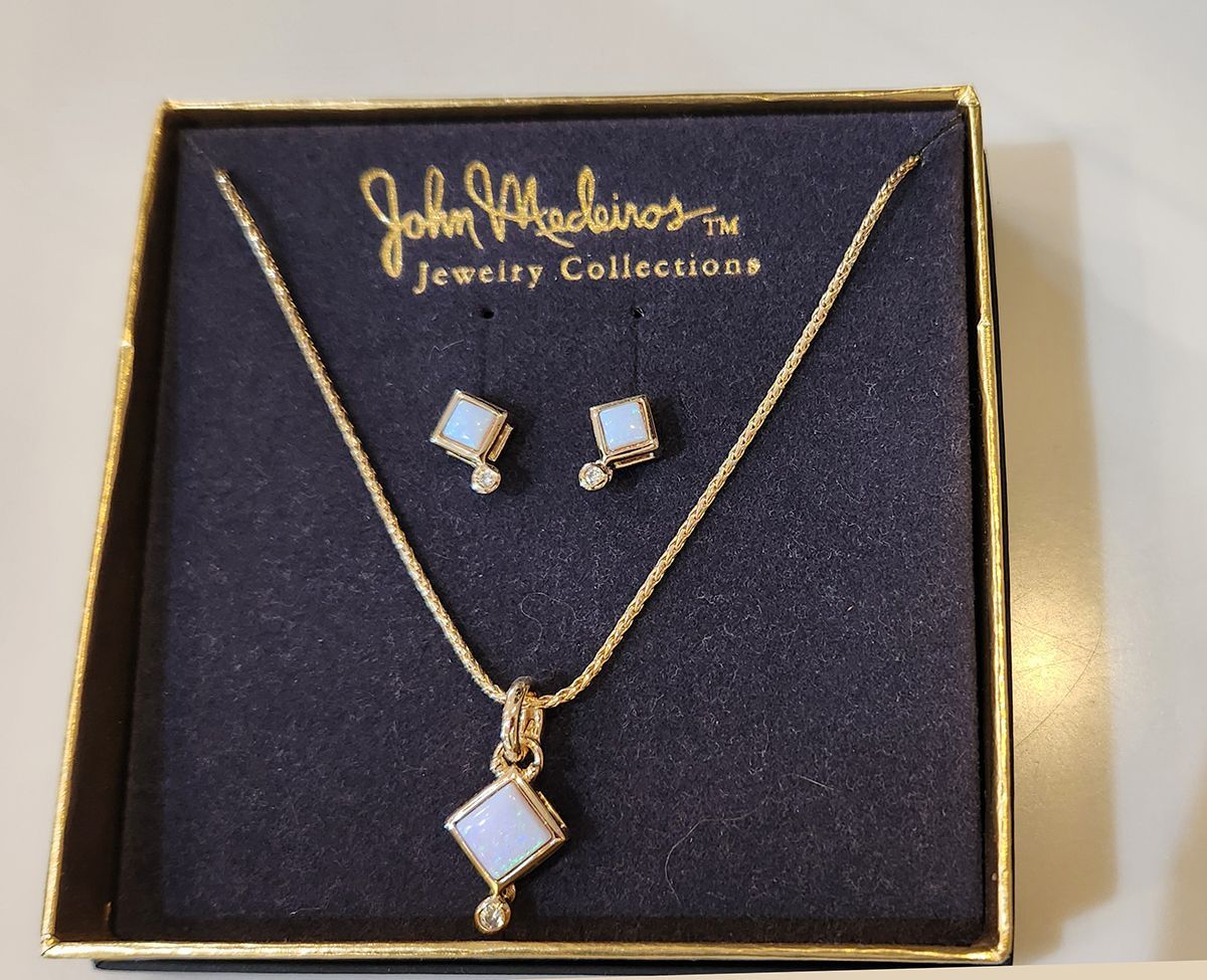 Gold jewelry set in a black box: necklace with pendant and matching stud earrings
