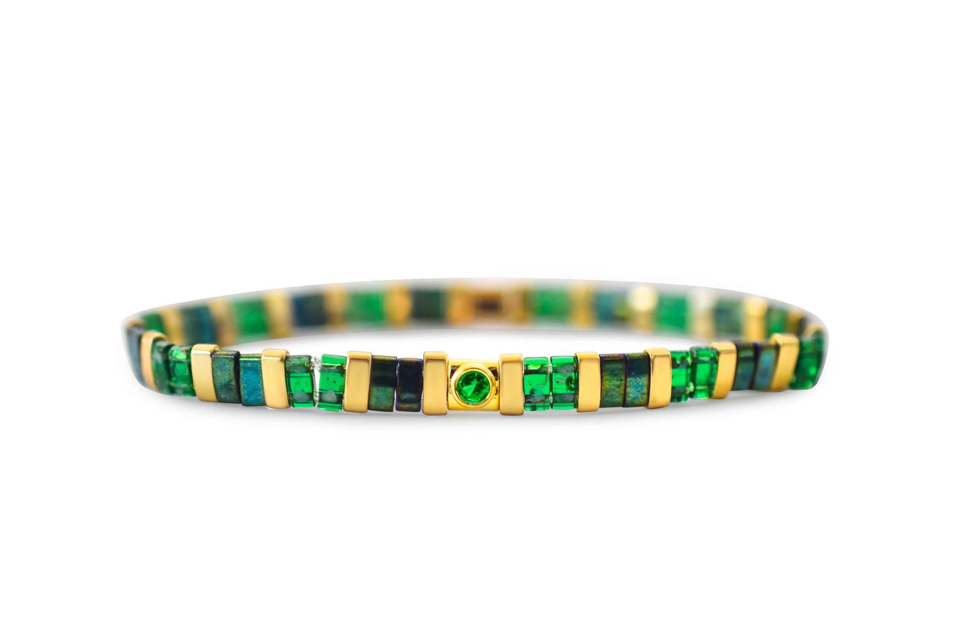 Green and gold woven bracelet with a small central charm on a white background