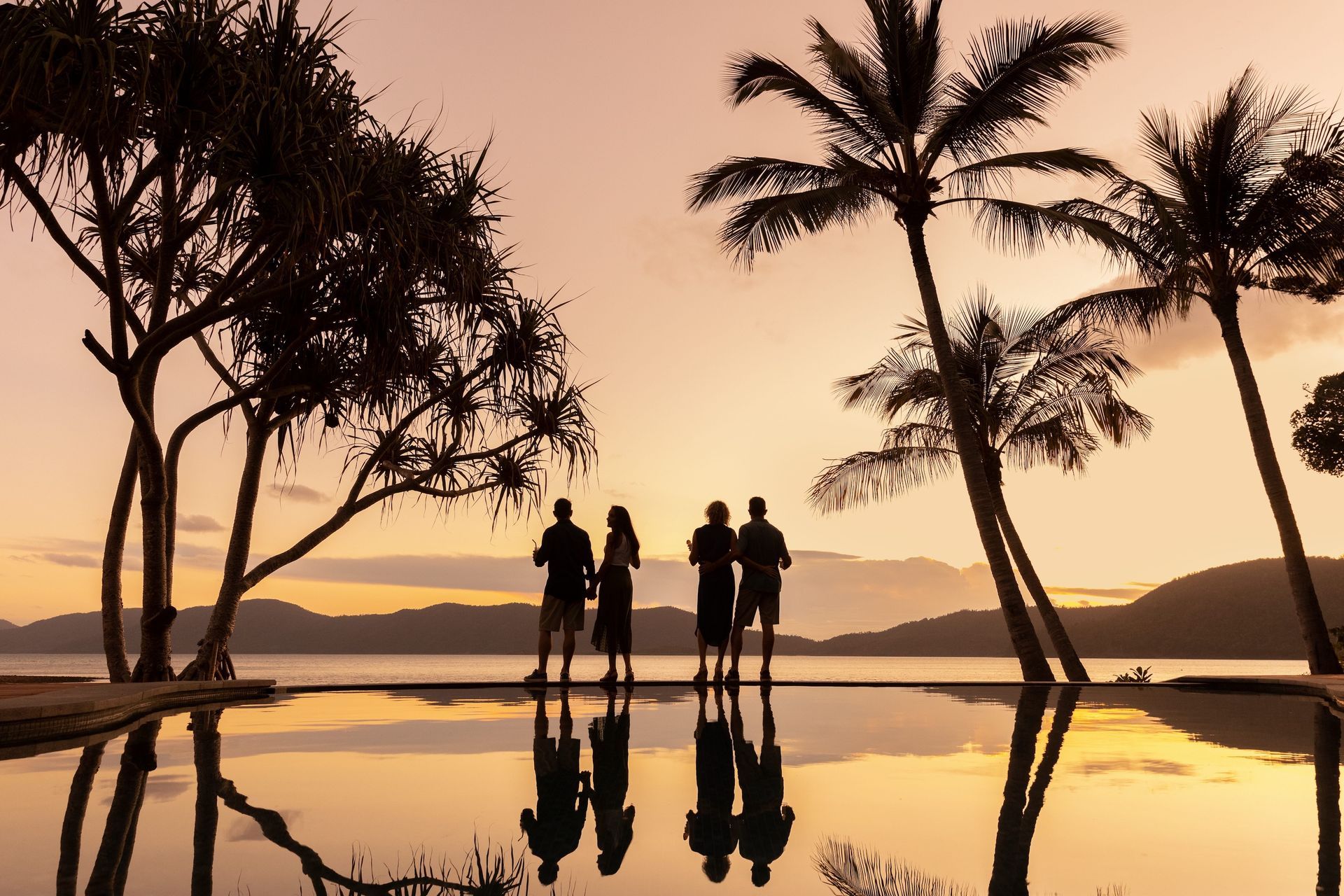 Travellers enjoying a tropical Australian sunset overlooking the Whitsunday Islands