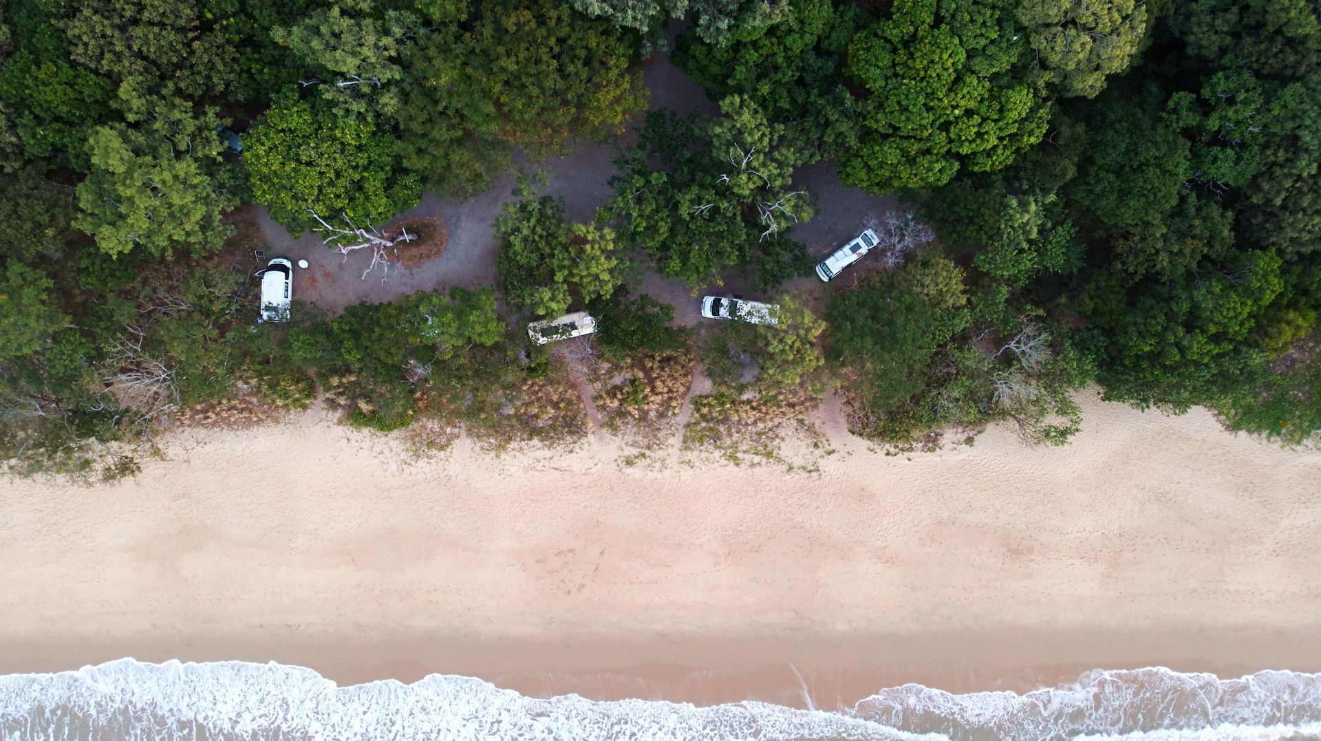 Aerial view of campervans parked beside a beach along Australia's east coast