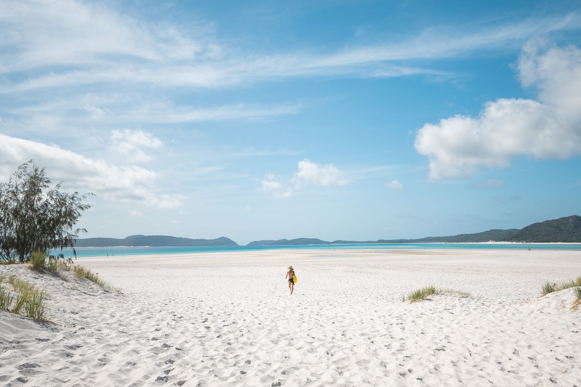 Traveller walking across Whitehaven Beach in the Whitsunday Islands during an Australian holiday