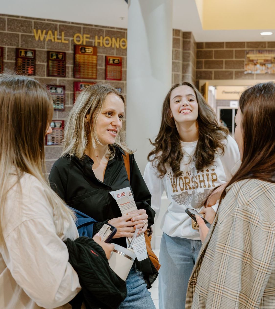 A group of women are standing in front of a wall that says wall of hong