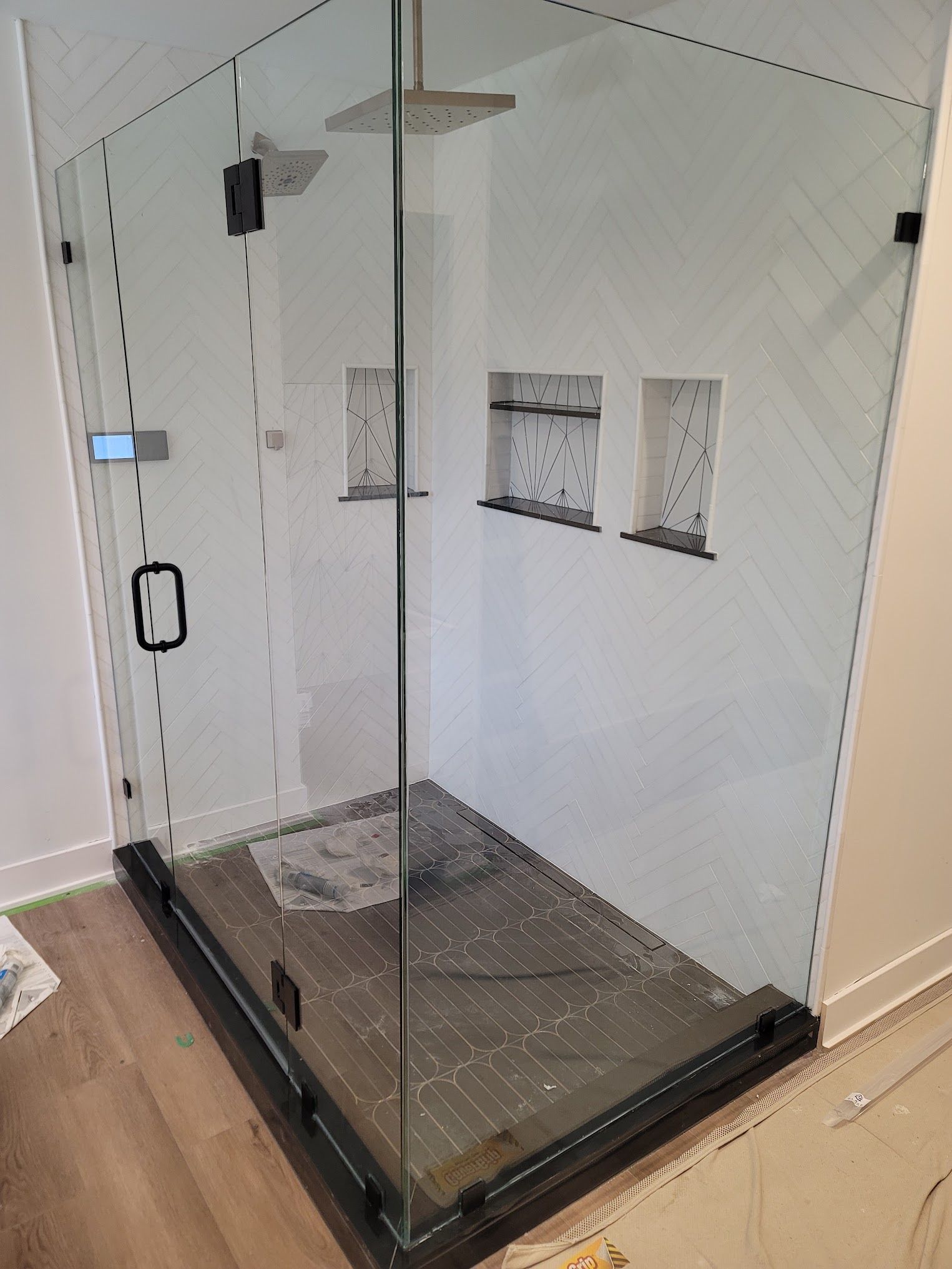 A shower stall with a glass door in a bathroom.